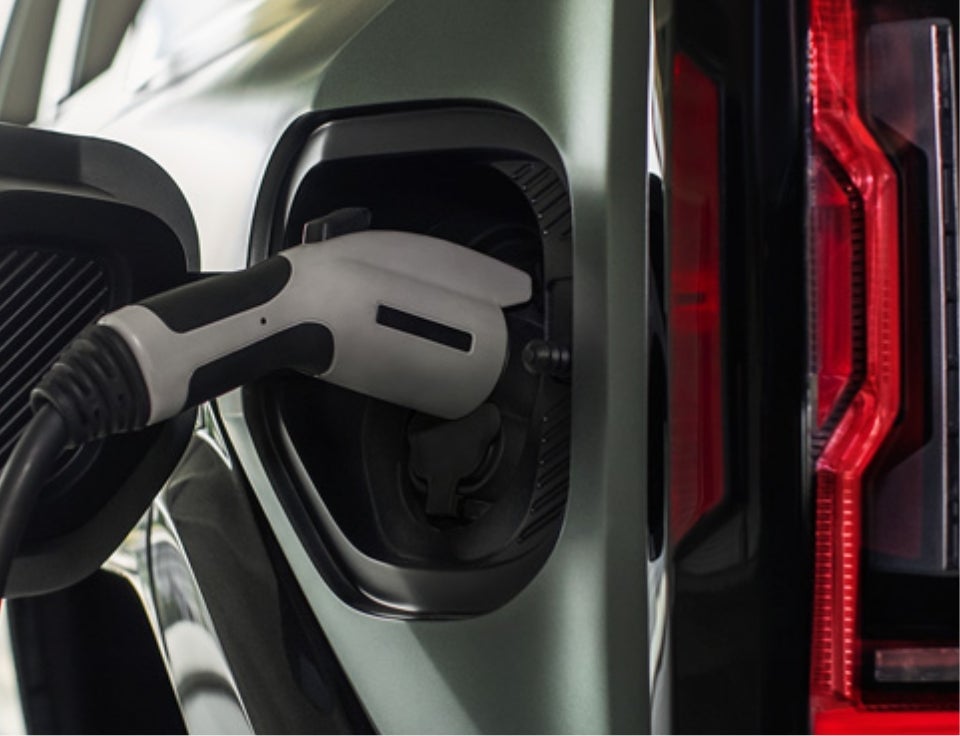 Close up of charging port with charger plugged in on a GMC Hummer EV SUV - Steele GMC Round Rock in ROUND ROCK TX